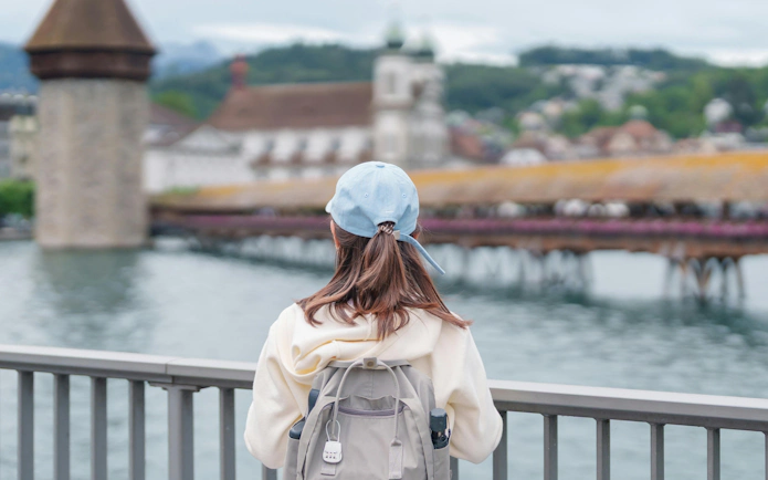 Tourist viewing Chapel Bridge and Water Tower on Reuss River in Lucerne, Switzerland.