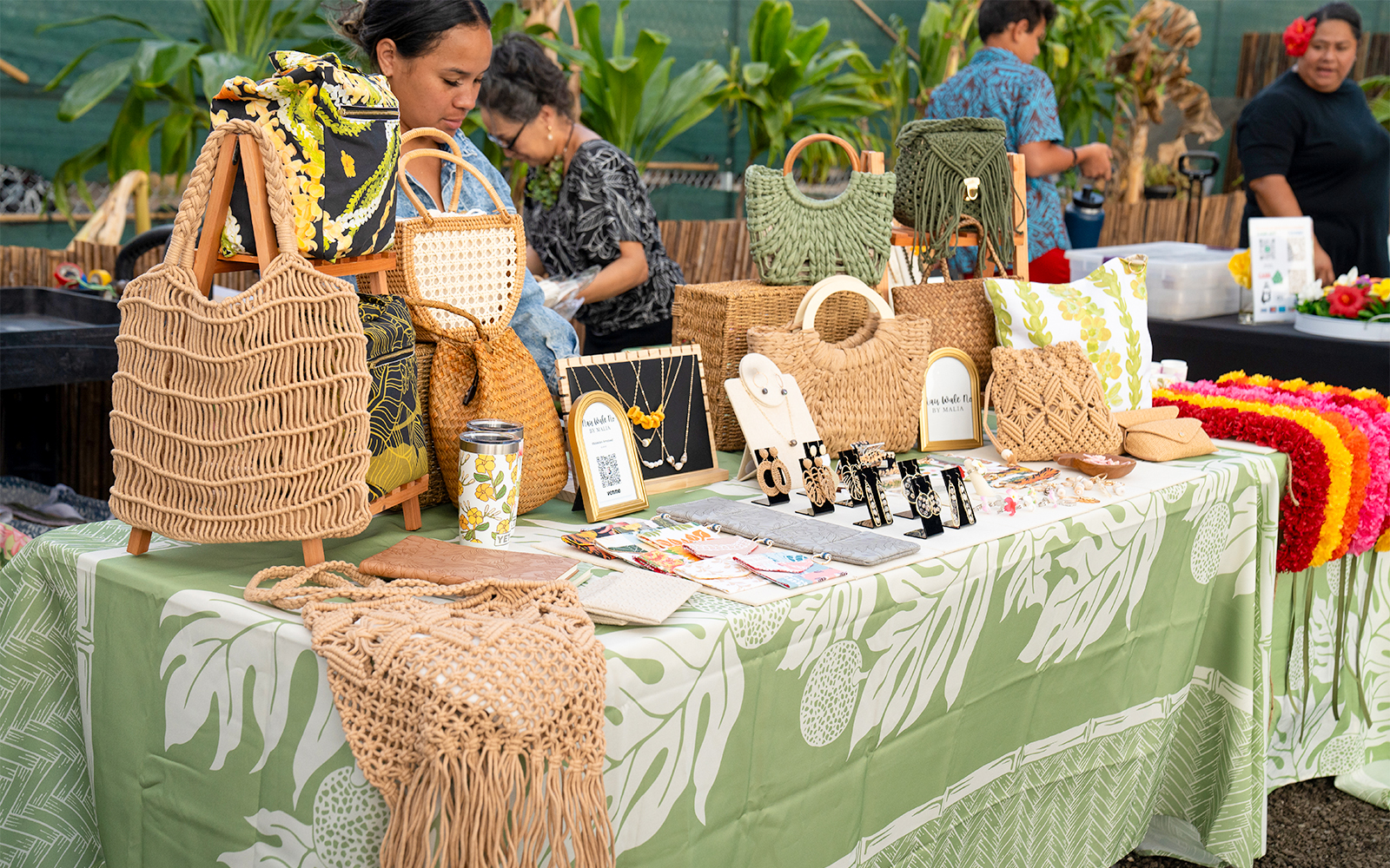 Handcrafted jewelry and bags displayed at Mauka Warriors Luau marketplace.