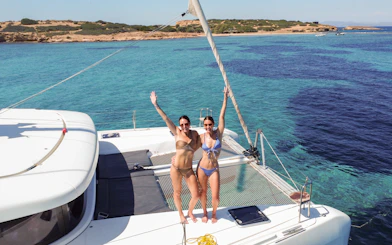 Guests enjoying a catamaran ride near a scenic coastline.
