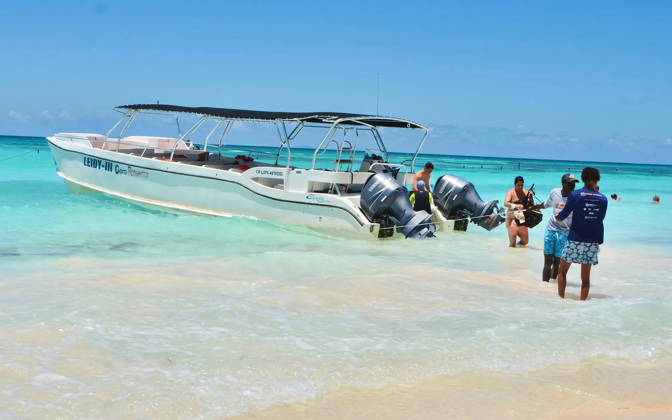 Catamaran anchored at Saona Island with tourists enjoying the clear waters, Punta Cana tour.