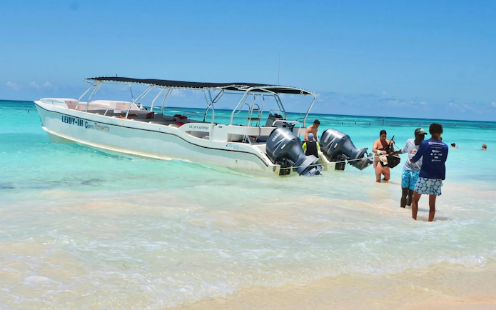 Catamaran anchored at Saona Island with tourists enjoying the clear waters, Punta Cana tour.