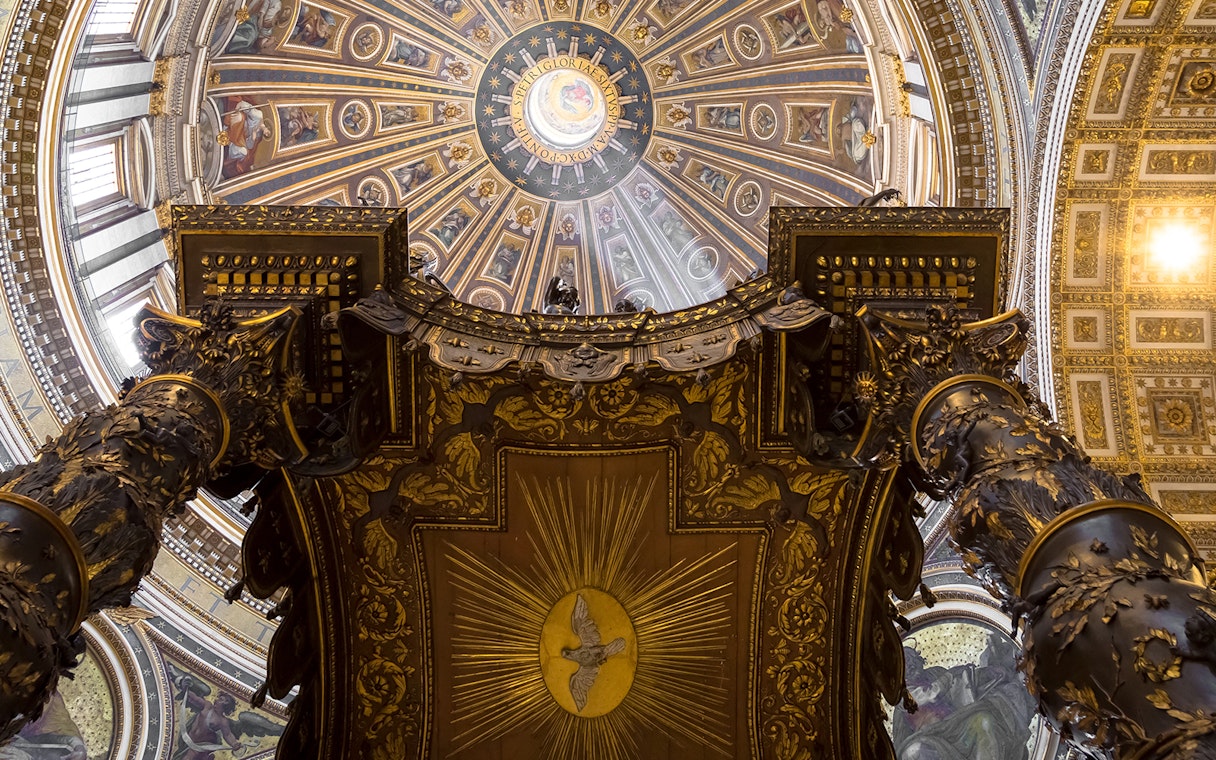 St. Peter’s Basilica Dome interior view with ornate columns and detailed ceiling artwork.
