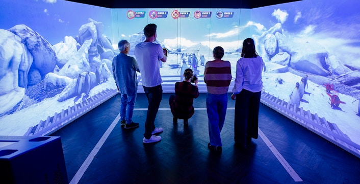 Visitors engaging with interactive penguin exhibit at Planet Wildlife Immersive Exhibition.