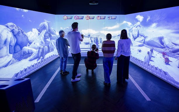 Visitors engaging with interactive penguin exhibit at Planet Wildlife Immersive Exhibition.