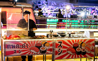 Sushi chef preparing dishes on Riverside Kinlen Cruise in Bangkok.