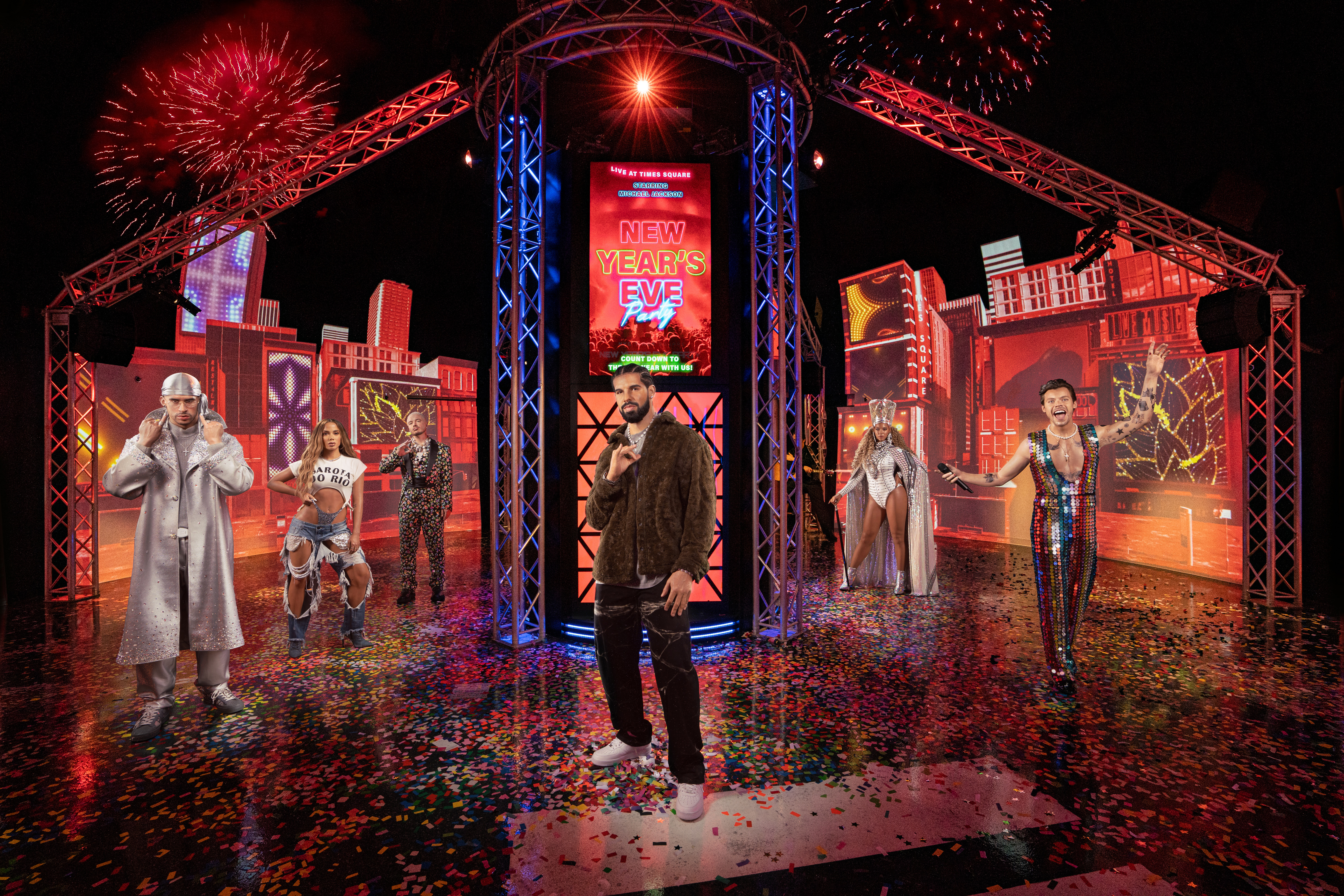 Wax figures of music artists at Madame Tussauds New York with fireworks and city backdrop.