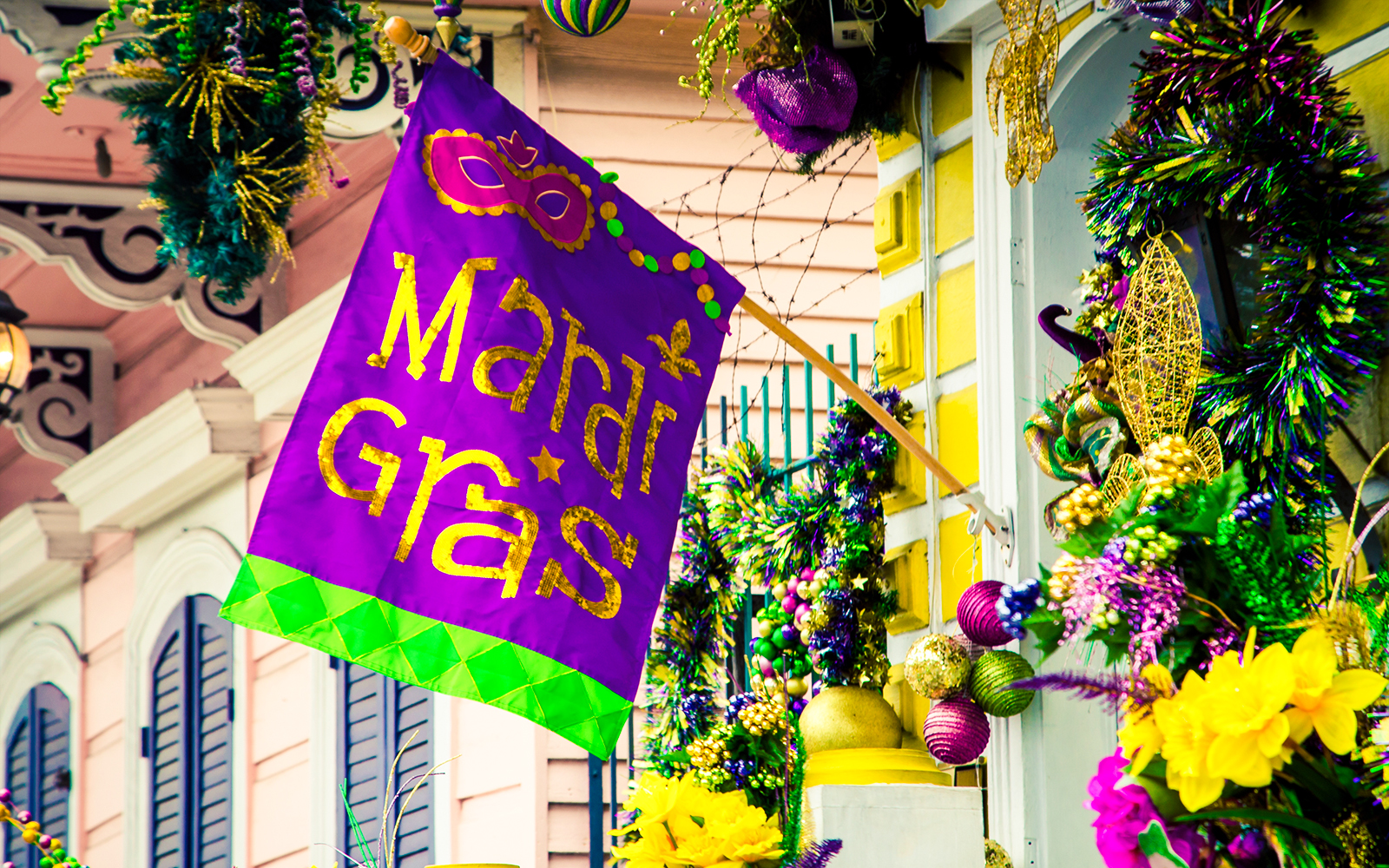 Mardi Gras flag and colorful decorations on a New Orleans balcony.