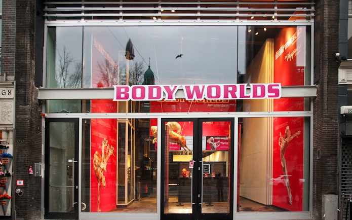 Body Worlds Amsterdam entrance with red interior displays.