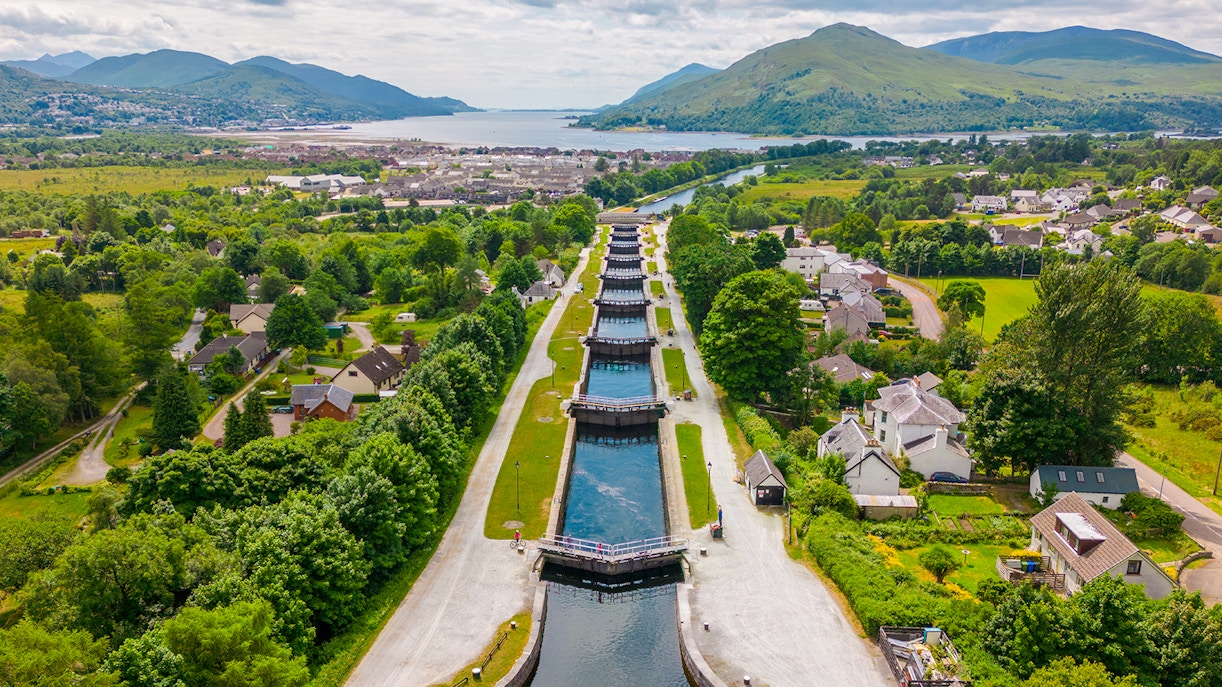 Aerial view of the Caledonian Canal with locks and surrounding greenery in Scotland.