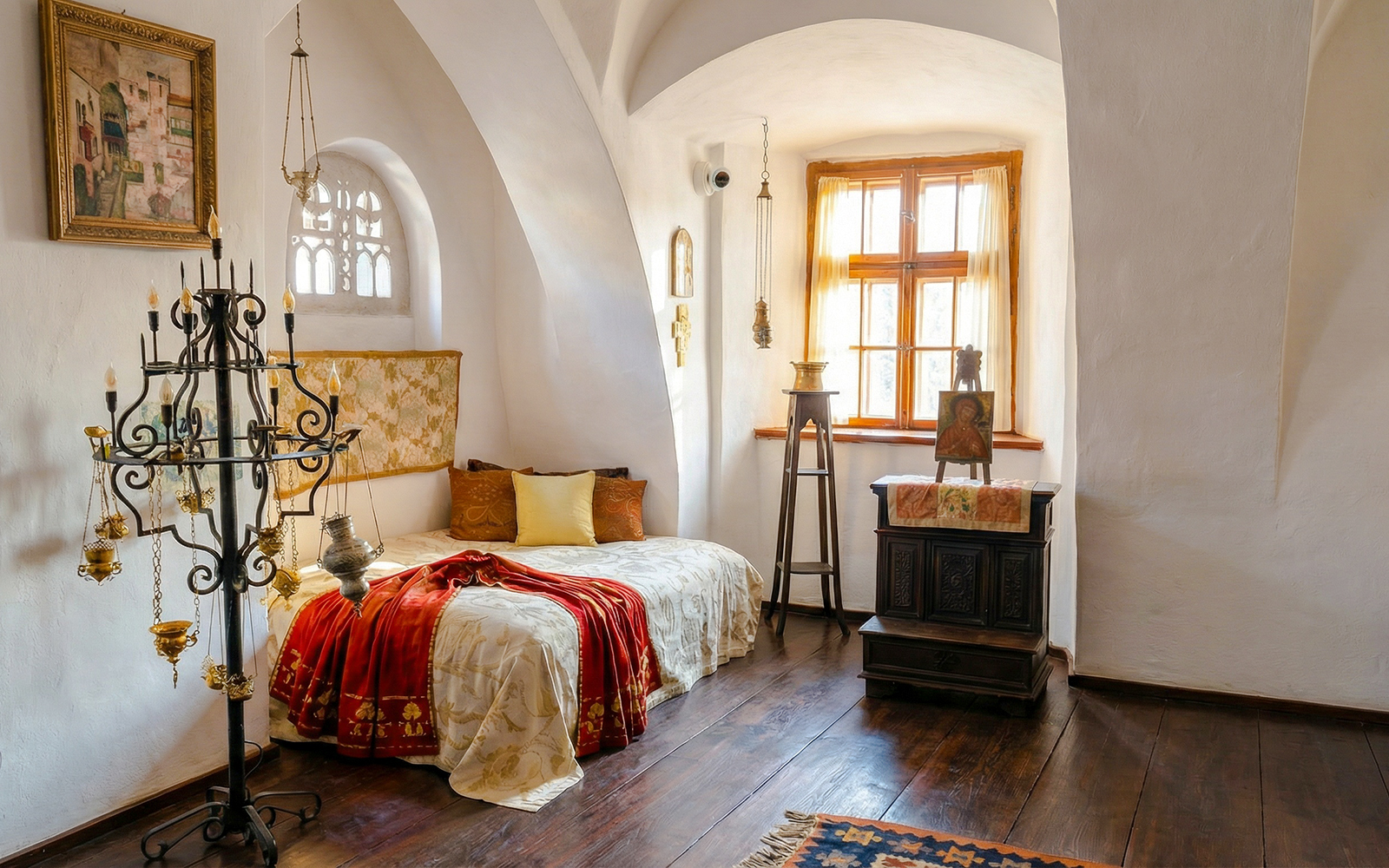 Bran Castle Romania interior with ornate bed, chandelier, and wooden furniture.