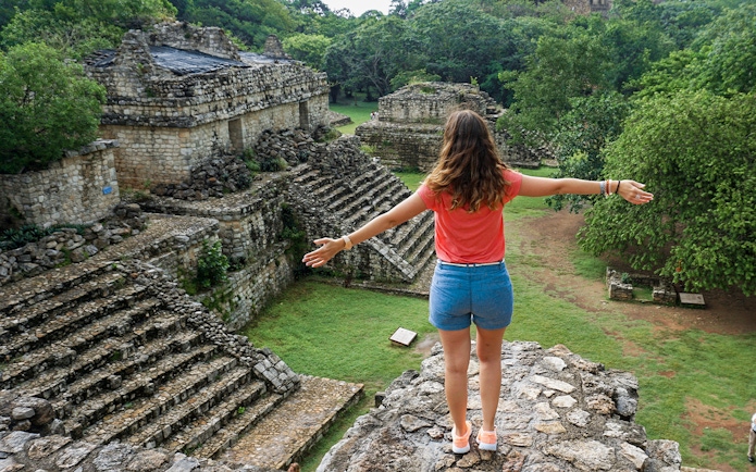 Woman overlooking ancient Mayan ruins in Yaxchilan, Mexico.