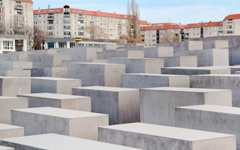 Holocaust Memorial in Berlin with concrete slabs and surrounding buildings.