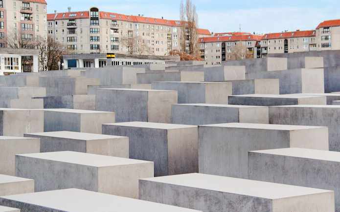 Holocaust Memorial in Berlin with concrete slabs and surrounding buildings.