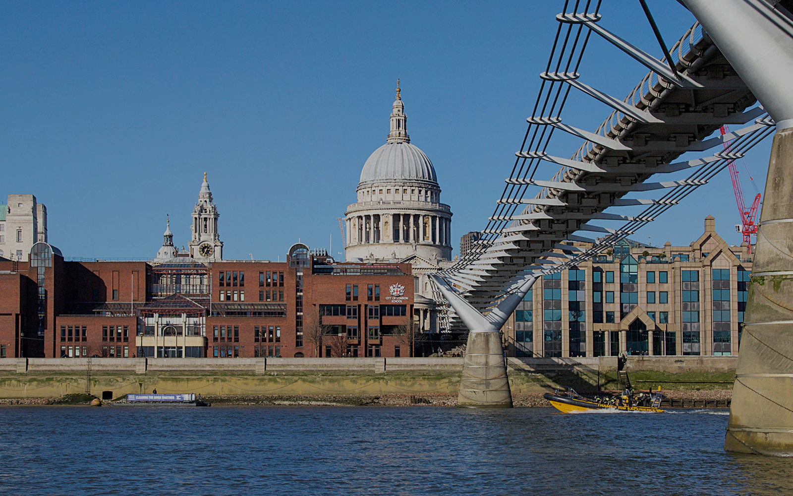 St. Paul's Cathedral viewed from the Thames River with Millennium Bridge in London.