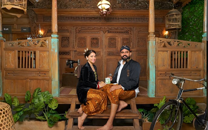 Couple in traditional Balinese attire at Asana Artseum, Garuda Wisnu Kencana, Bali.