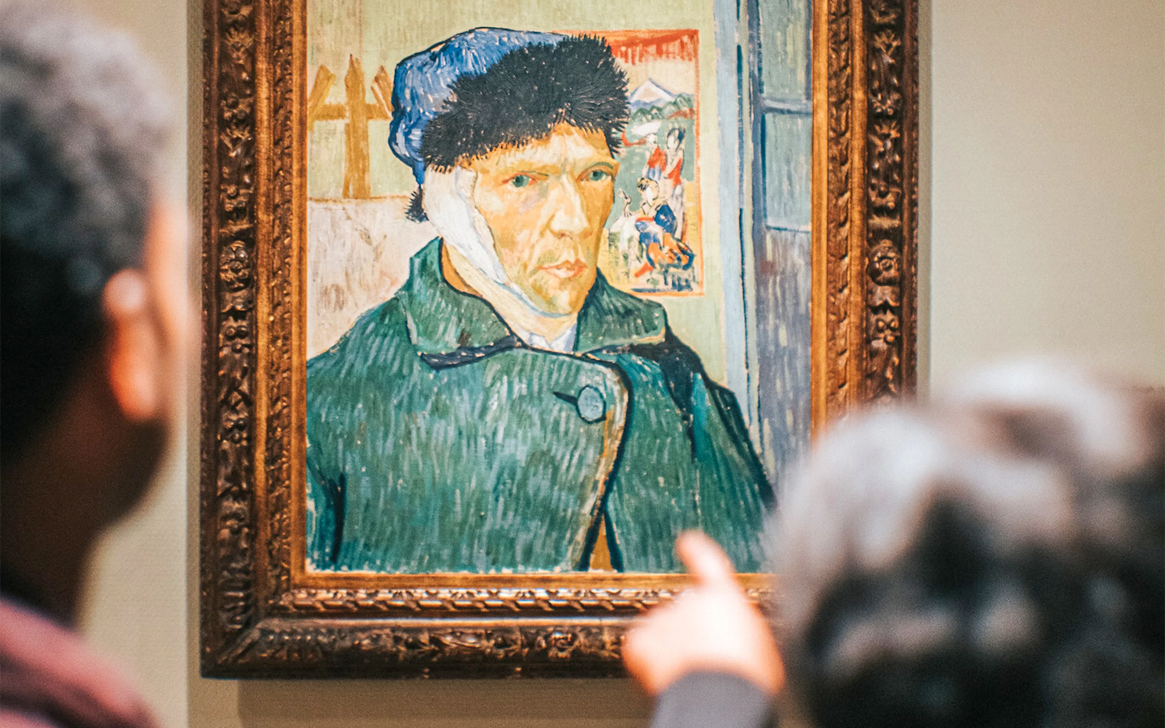 Visitors viewing Van Gogh self-portrait at Van Gogh Museum, Amsterdam.