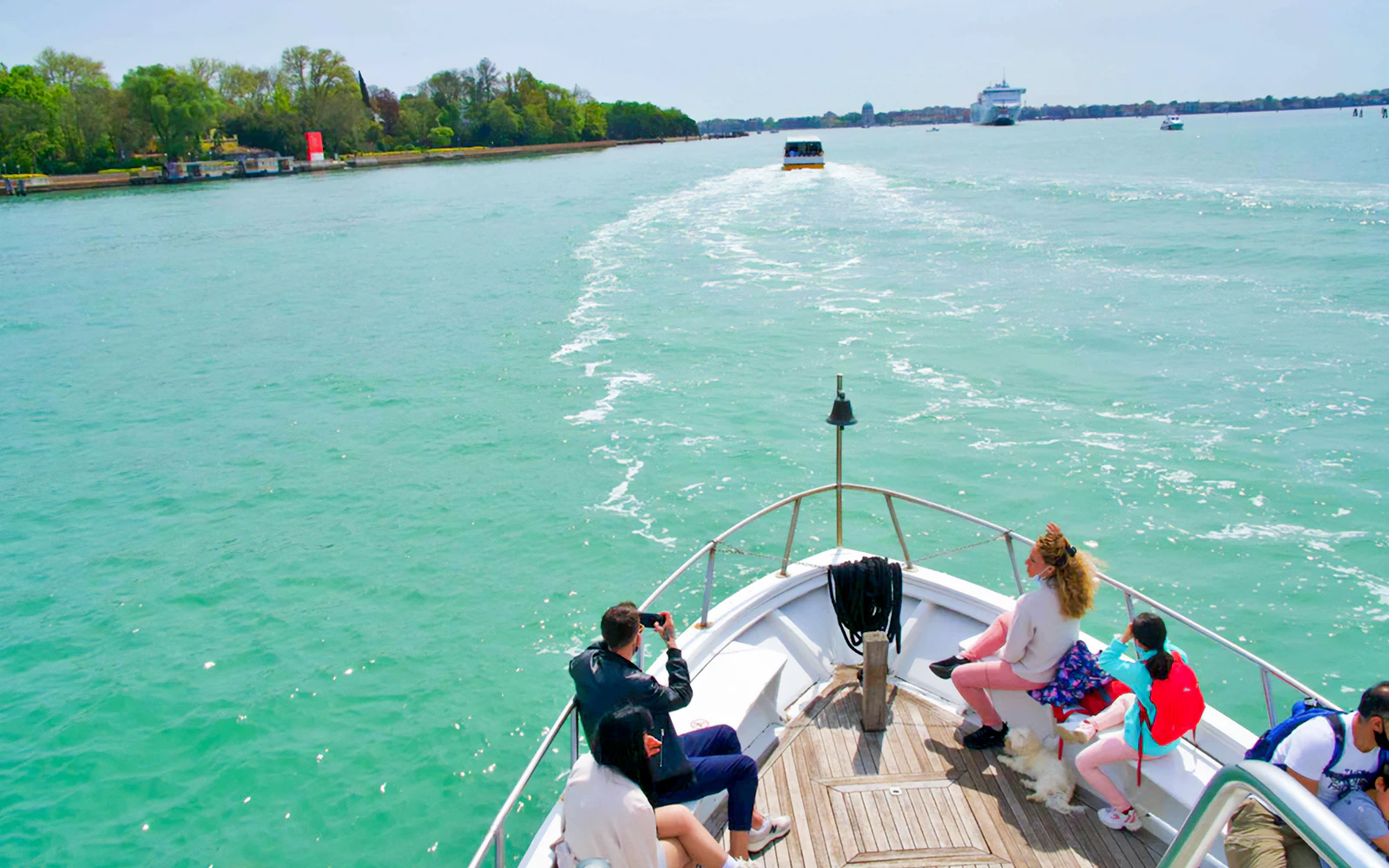 Tourists on a boat enjoying views of Murano, Burano, and Torcello Islands.