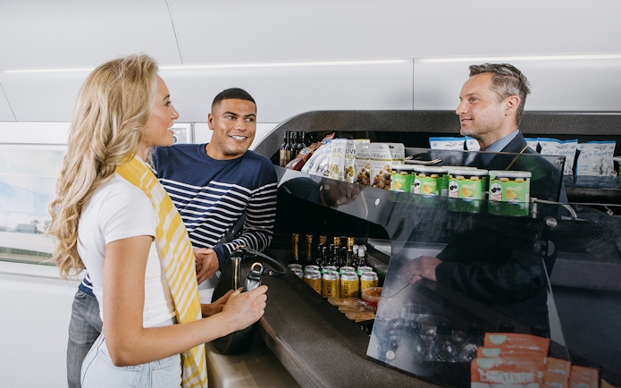 Travelers at a snack bar on a train in Germany using the Interrail Germany Mobile Pass Flex.