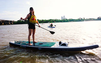 Paddleboarding on the Red River near Nhat Tan Bridge at sunset, Hanoi.