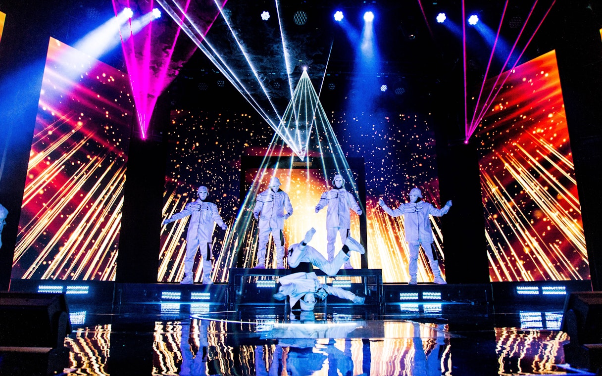 Jabbawockeez dancers performing on stage with vibrant lights in Las Vegas show.