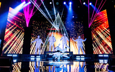 Jabbawockeez dancers performing on stage with vibrant lights in Las Vegas show.