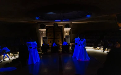 Whirling Dervishes performing Sema ceremony in a cave setting, Cappadocia.
