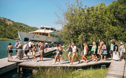 Tourists boarding a boat at Krka National Park during a Split wine tasting tour.