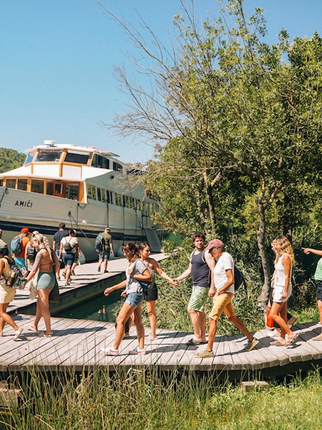Tourists boarding a boat at Krka National Park during a Split wine tasting tour.