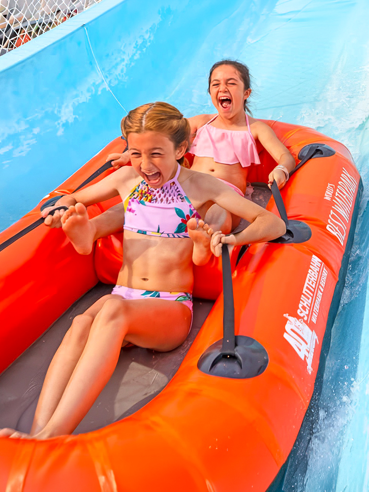 Two children enjoying the Master Blaster Uphill Water Coaster at Schlitterbahn, Six Flags, New Braunfels.