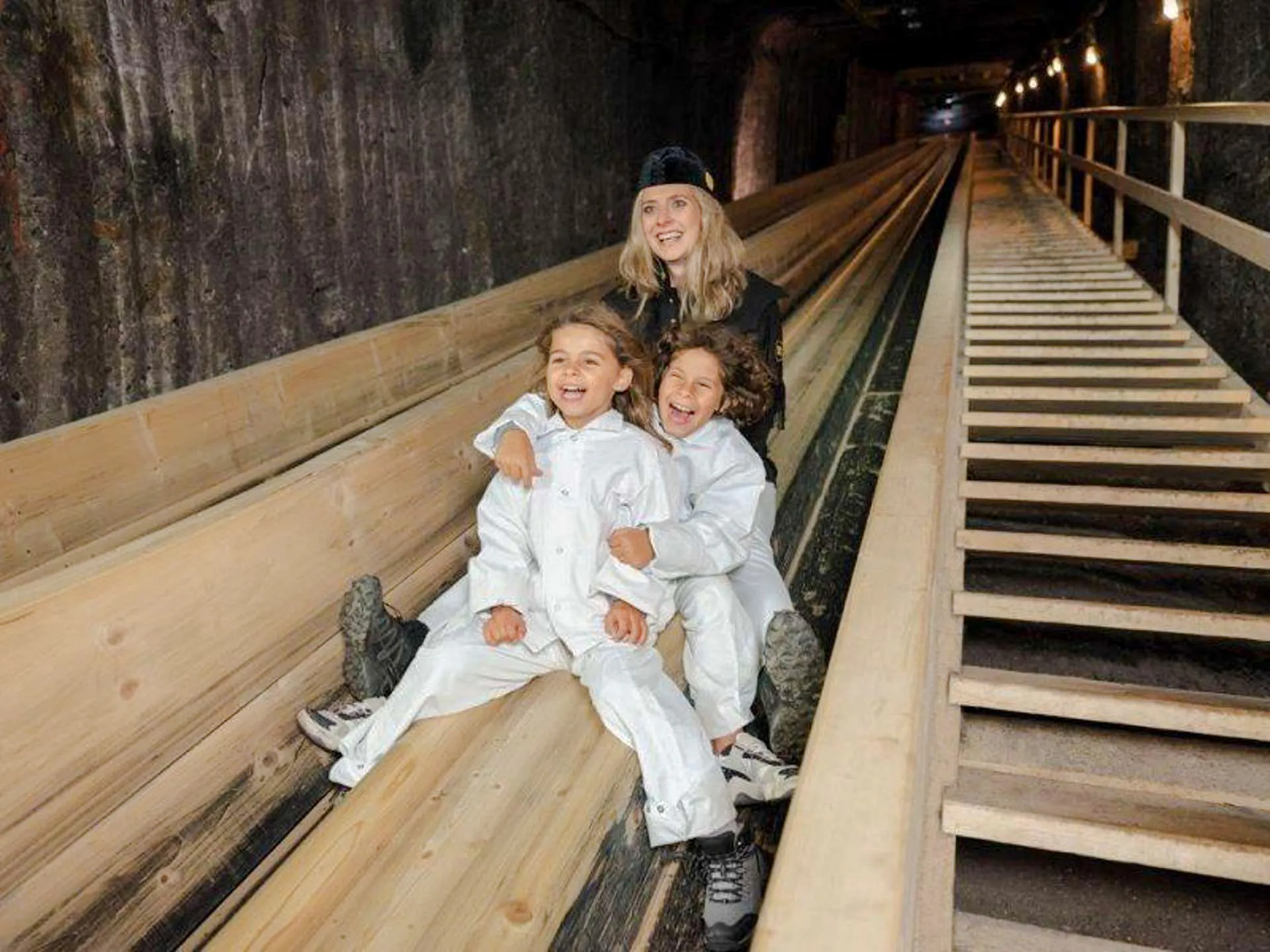 Visitors sliding in Hallstatt Salt Mine during Salzburg tour.