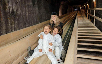 Visitors sliding in Hallstatt Salt Mine during Salzburg tour.