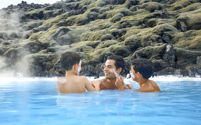Family enjoying geothermal waters at Blue Lagoon, Iceland.