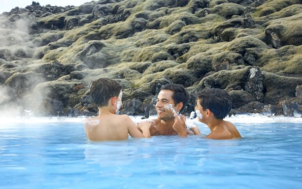 Family enjoying geothermal waters at Blue Lagoon, Iceland.