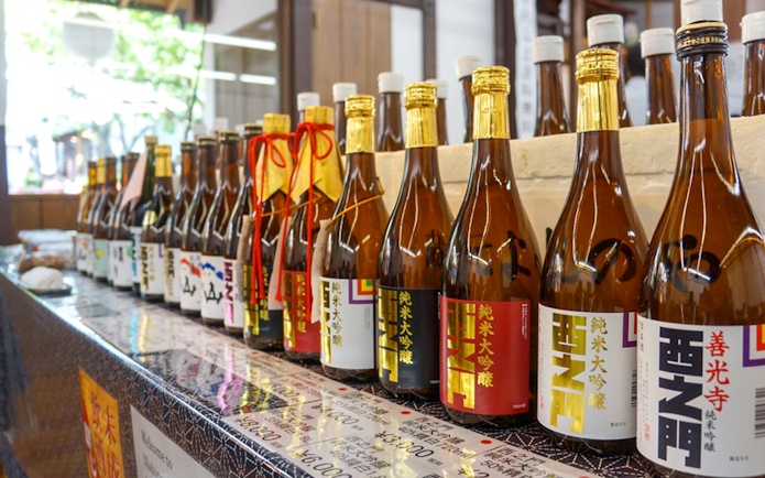 Sake bottles displayed at a brewery in Nagano, part of the Zenko-ji Temple and Snow Monkey Park tour.