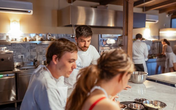 Cooking class participants preparing dishes in a Palermo kitchen.