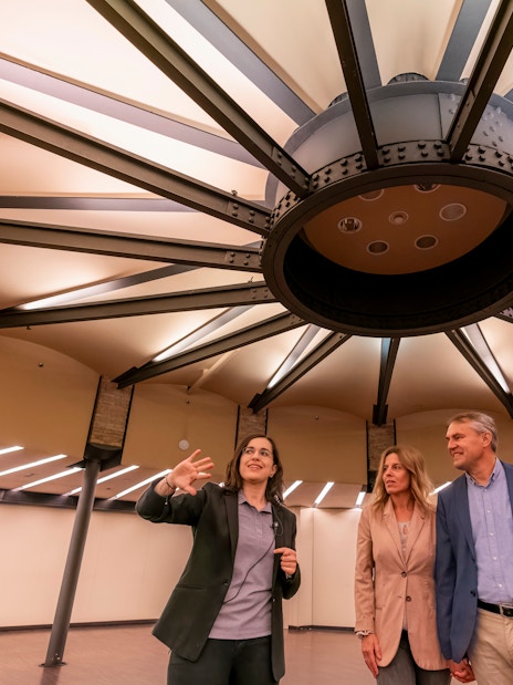 Tourist with guide examining ceiling design inside Casa Mila, Barcelona.