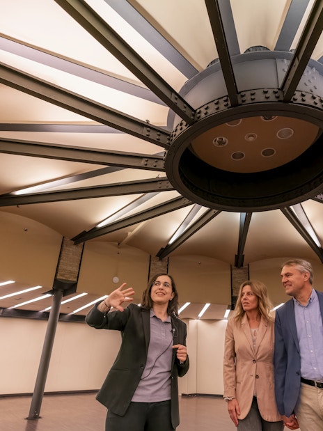Tourist with guide examining ceiling design inside Casa Mila, Barcelona.