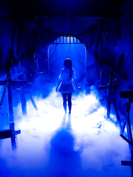 Silhouette of a person in a foggy, blue-lit room with crosses, part of The Conjuring Universe Tour in Bangkok.