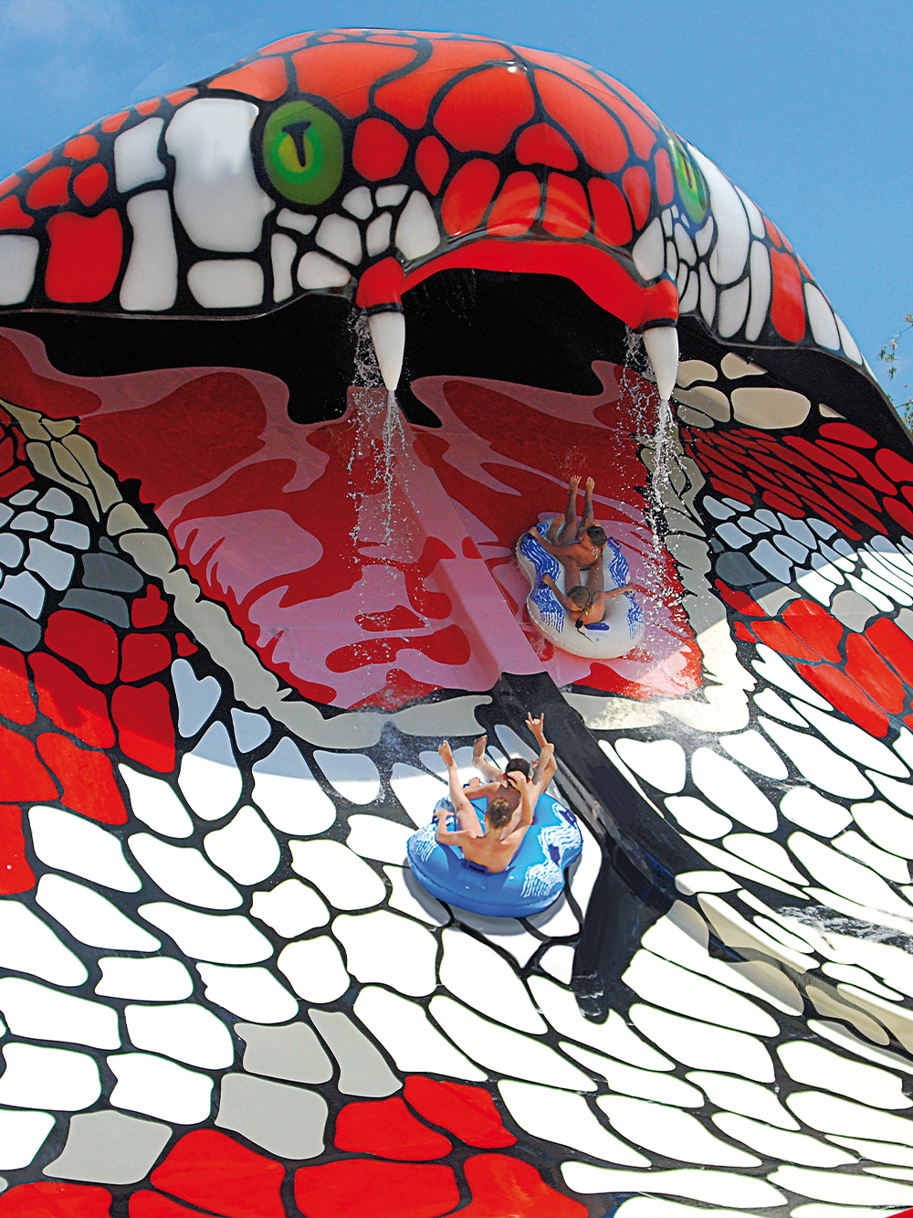 Visitors sliding down the snake-themed water slide at Aqualand El Arenal, Mallorca, Spain.