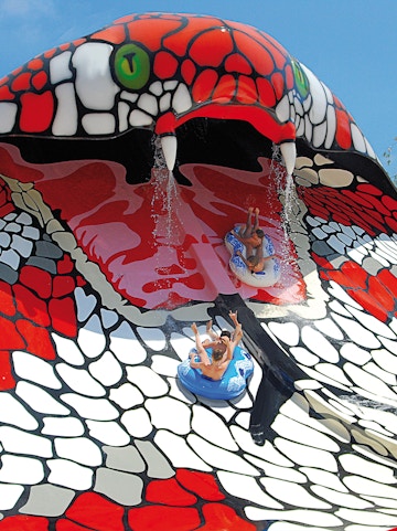 Visitors sliding down the snake-themed water slide at Aqualand El Arenal, Mallorca, Spain.