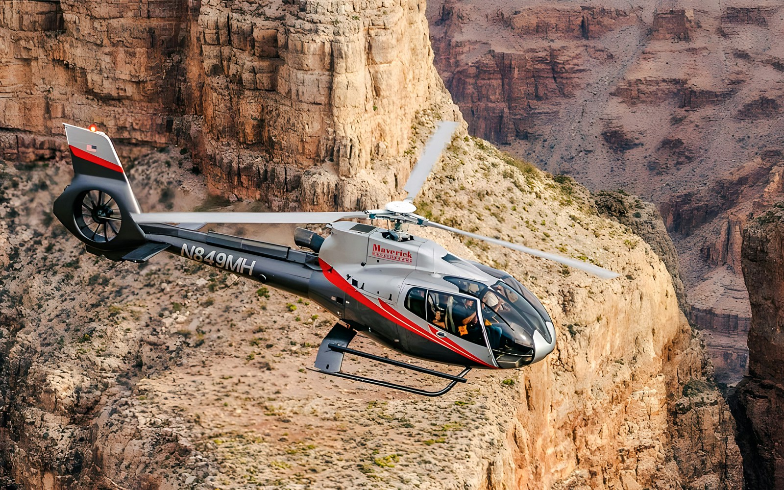 Maverick Helicopters Airbus EC130 flying over Grand Canyon with Las Vegas Strip views.
