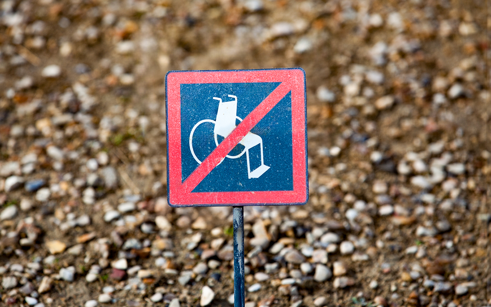 No wheelchair access sign on gravel path.
