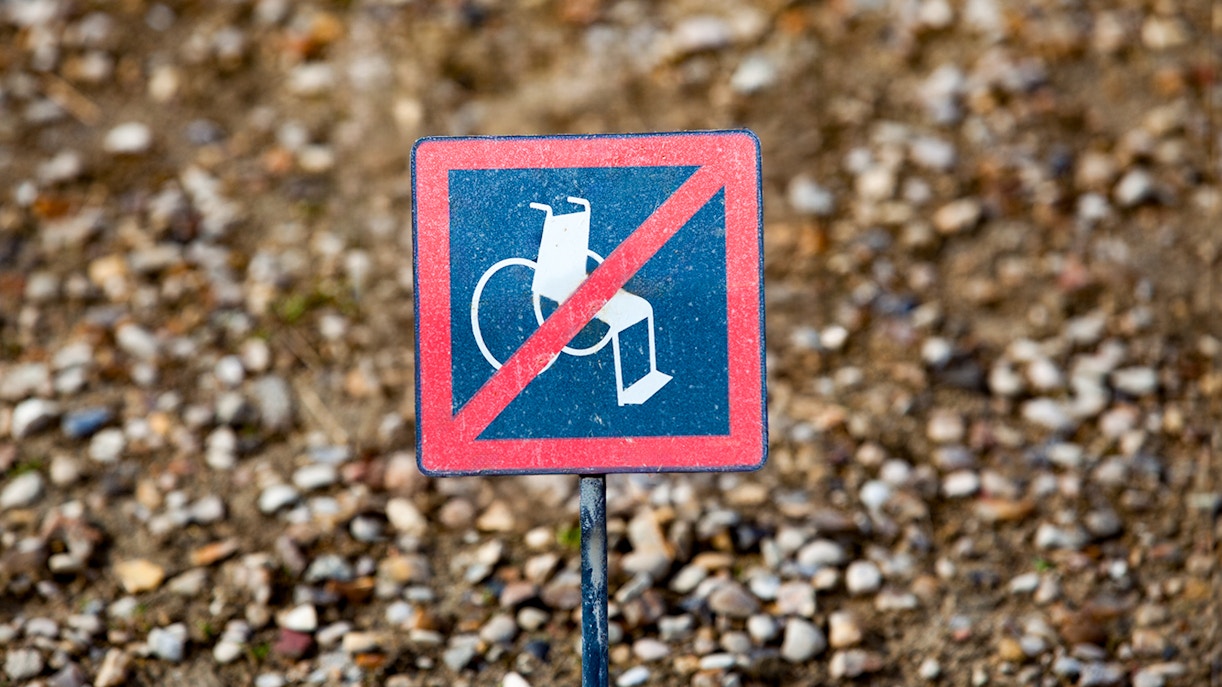 No wheelchair access sign on gravel path.