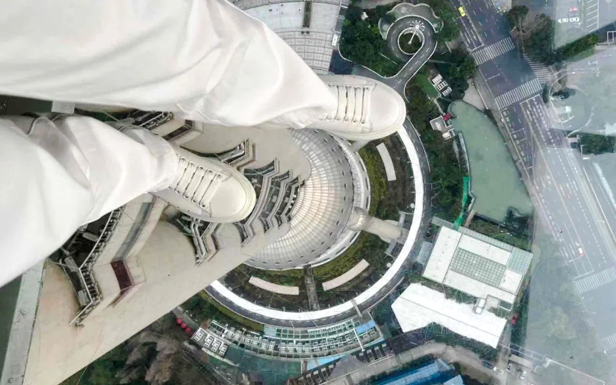View from Oriental Pearl Tower observation deck, Shanghai, looking down at city streets.