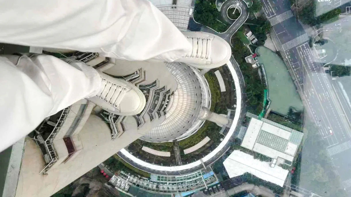 View from Oriental Pearl Tower observation deck, Shanghai, looking down at city streets.