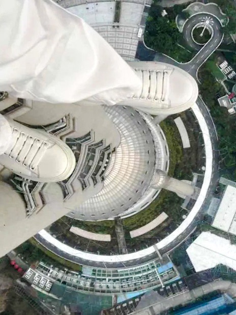 View from Oriental Pearl Tower observation deck, Shanghai, looking down at city streets.