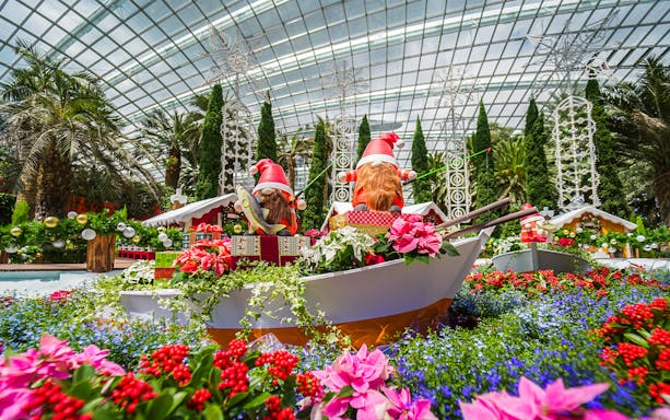 Gardens by the Bay festive display with Santa figures and vibrant flowers in Flower Dome.