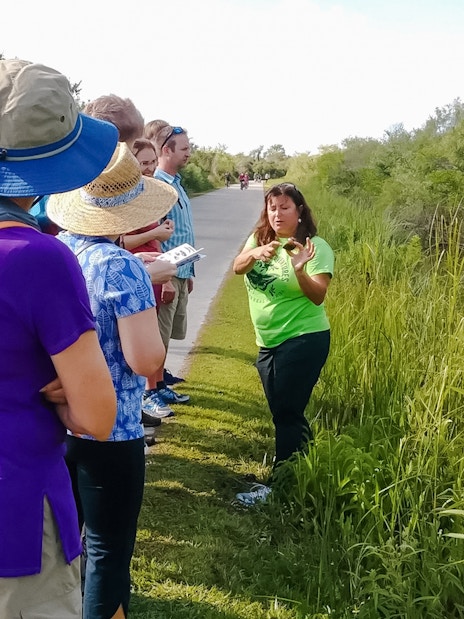 Tour guide explaining flora to guests on Everglades nature trail.