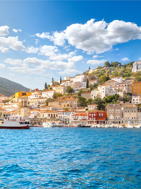Hydra island waterfront with colorful buildings and boats, part of Athens island cruise.