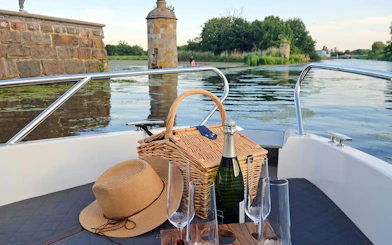 Wine and picnic basket on boat during Gdańsk Motława Sunset Cruise.